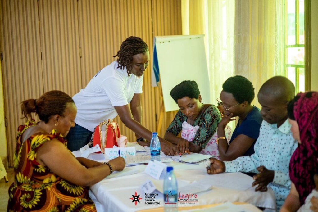Several people sit around a table with papers and notebooks during a group discussion.