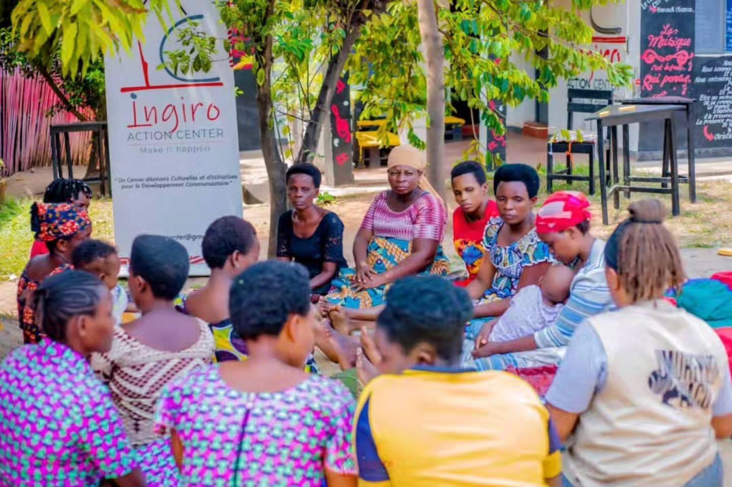 Participants gather outdoors around children and colorful school materials.