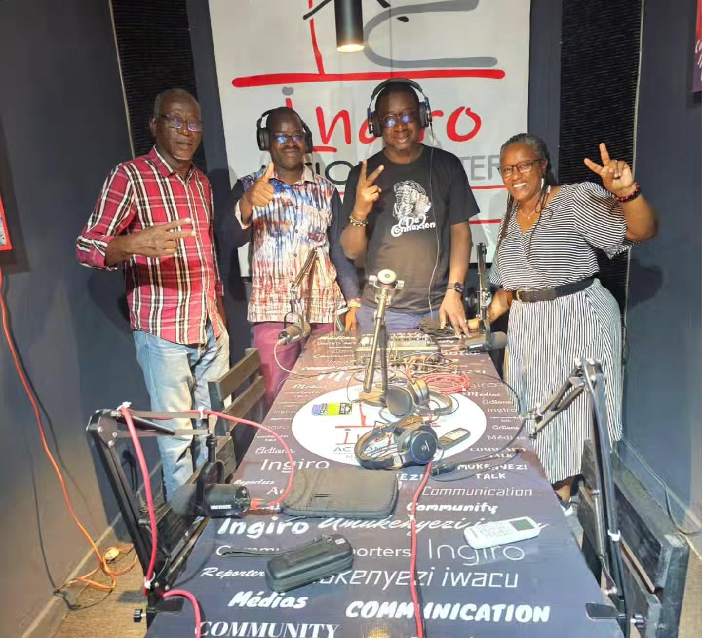 Four people pose together in front of an Ingiro Action Center sign.