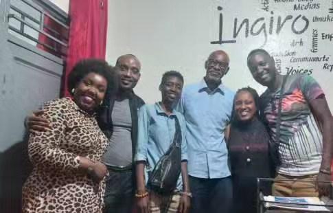 A group poses inside the Ingiro office beneath a wall sign.