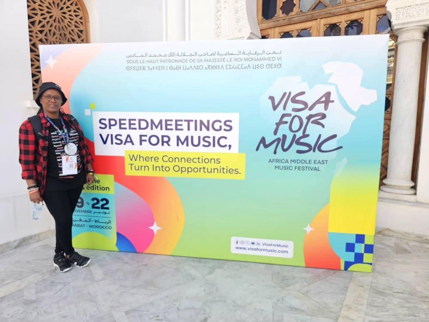 A man stands beside a Visa for Music event sign in a bright indoor space.